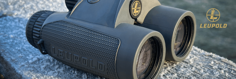 Leupold BX-4 Range HD hunting binoculars resting on a stone and wood surface