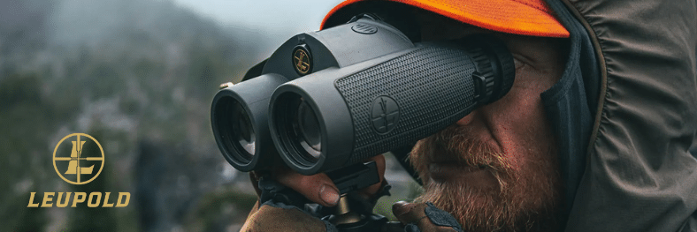 Man in orange cap and green weatherproof jacket looks through Leupold BX-4 Range HD Hunting Binoculars